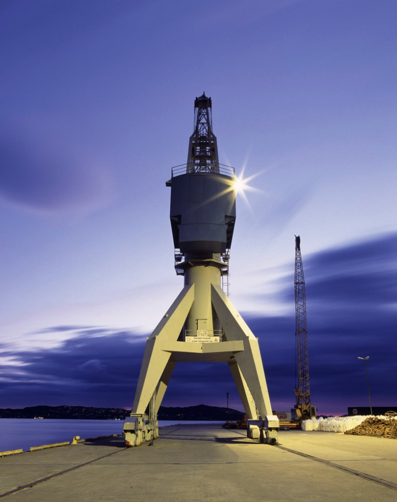 A crane standing by the docks at night time in Bergen, Norway.