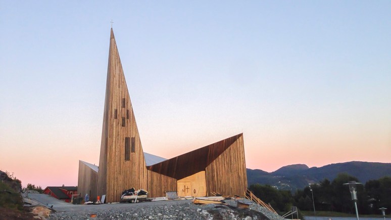 Overview of the church during construction at dusk.