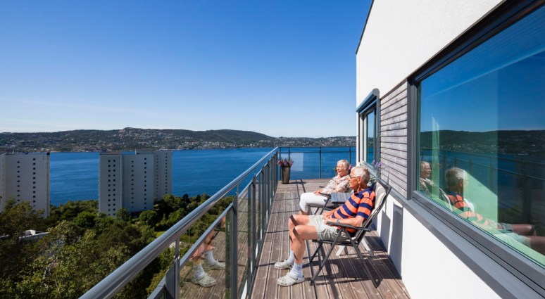 Retired couple enjoying the magnificent view from their new flat in Bergen.