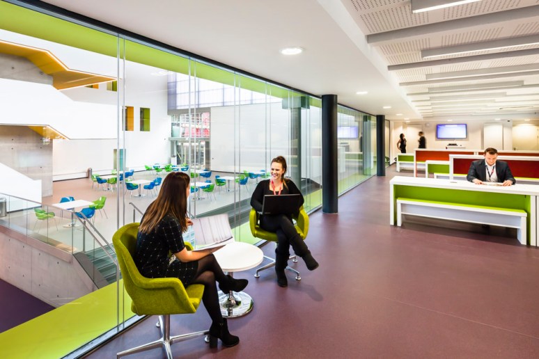 A female student and lecturer in one of the open plan classrooms, North Hertforshire College designed by Scott Brownrigg, Hitchin, UK
