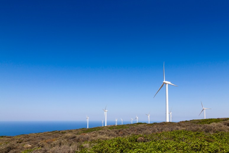 Wind Turbines on the cliff top outside of Elounda looking ot on to the Aegean Sea, Crete, Greece.
